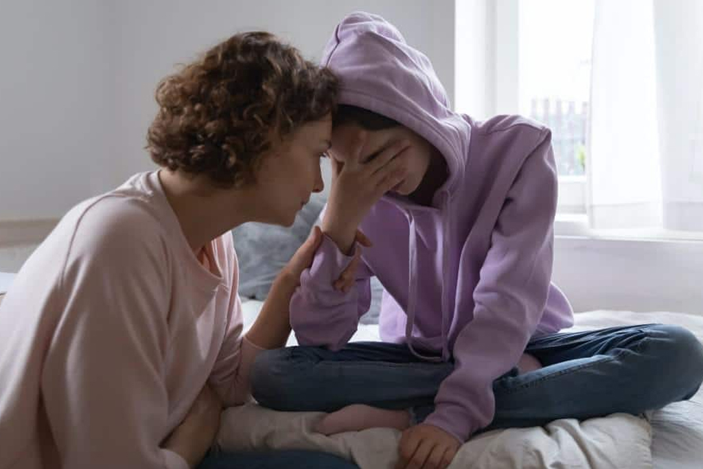 a mother comforts her teen daughter who is having suicidal thoughts